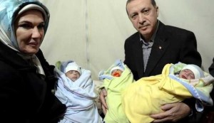 Turkish Prime Minister Tayyip Erdogan and his wife Emine Erdogan pose with Syrian refugee triplet babies near Akcakale border crossing on the Turkish-Syrian border, southern Sanl